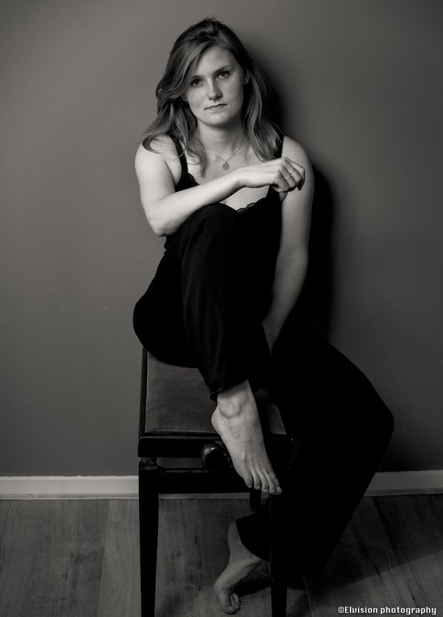 Black and white studio portrait, seated